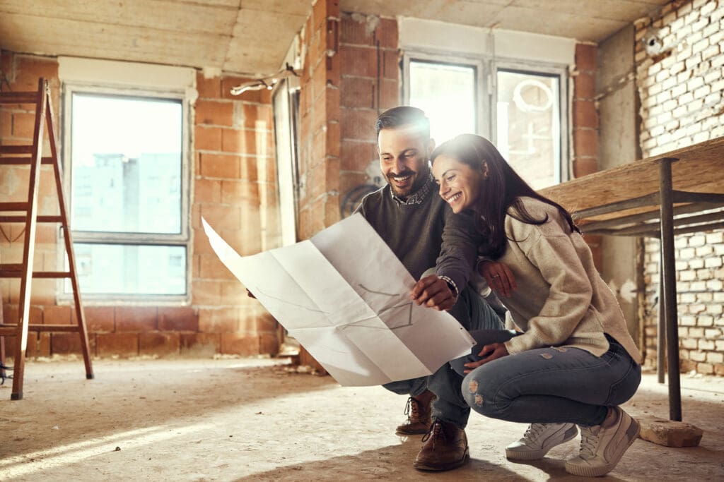 Couple planning home renovation with floor plans.