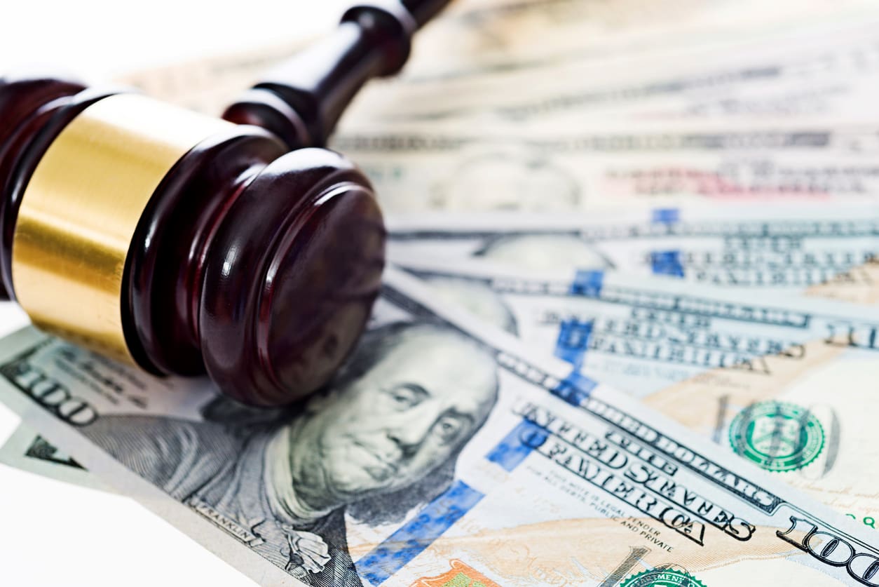 Gavel on hundred-dollar bills, legal costs concept.