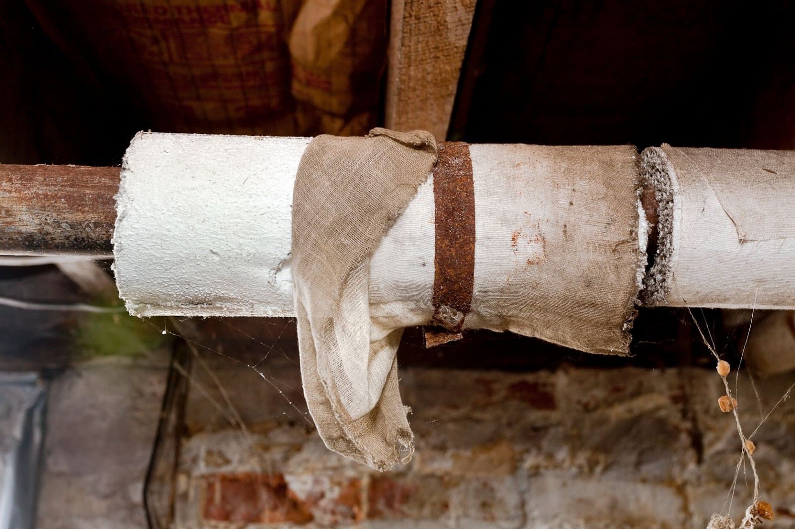 Old insulated pipe in a rustic basement.