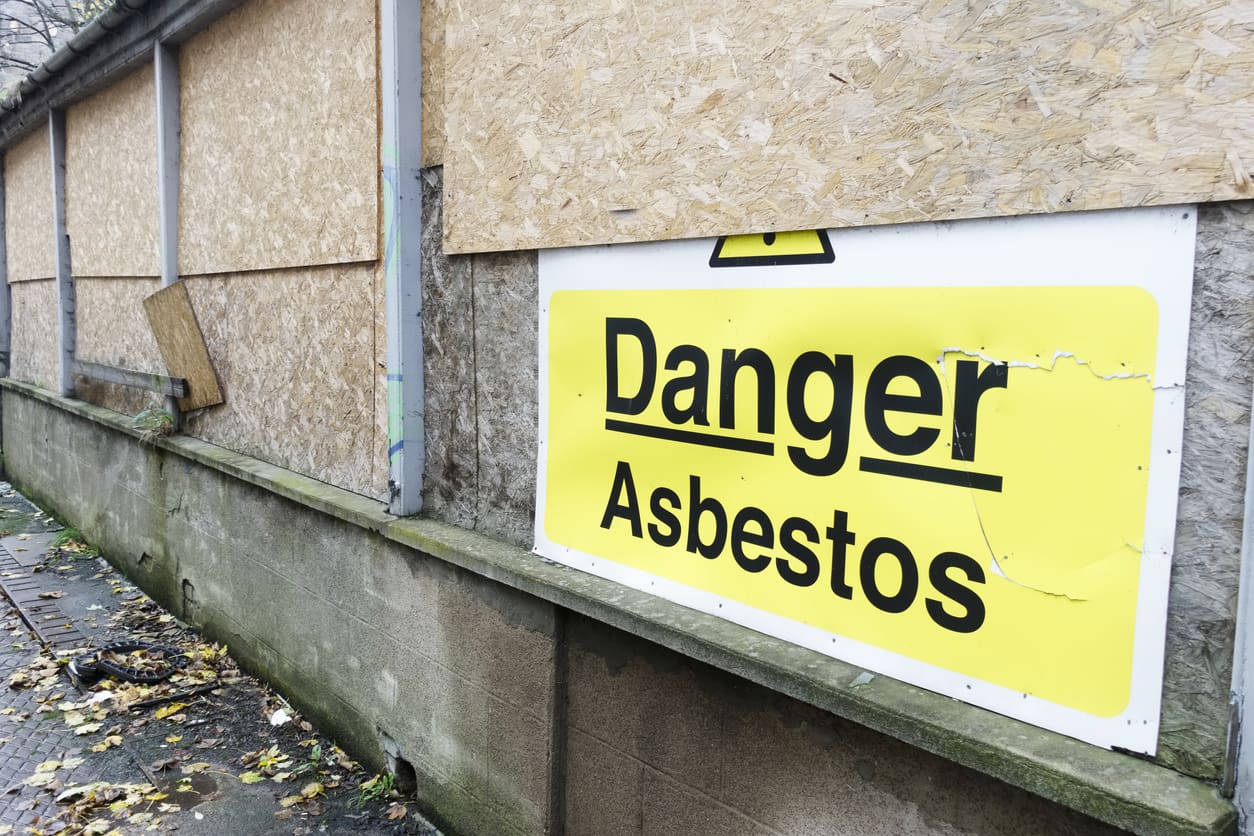 Yellow sign warning of asbestos danger.