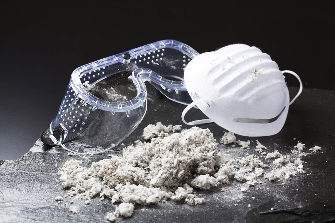 Safety goggles and mask with asbestos fibers closeup.